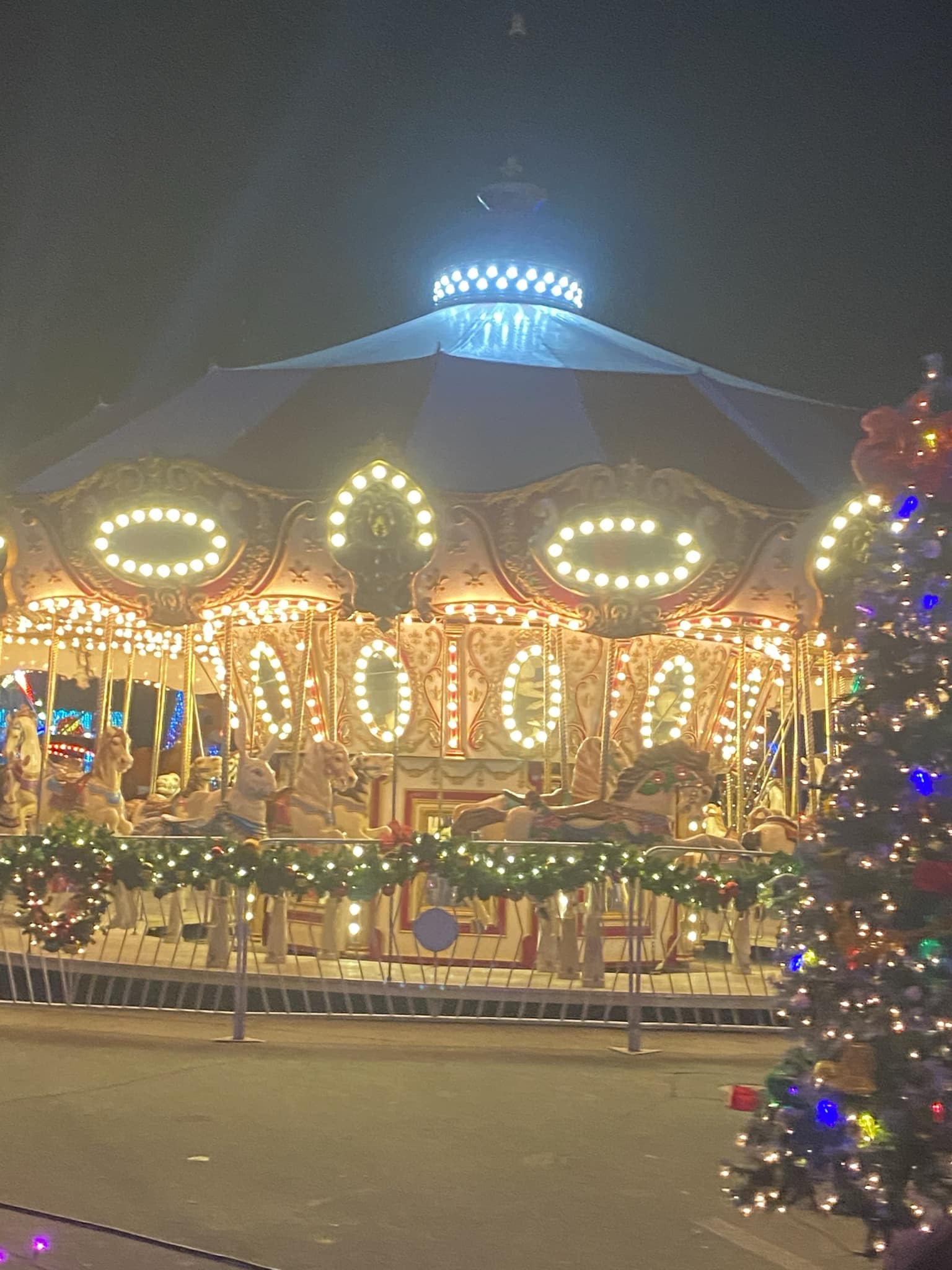 carousel decorated with Christmas lights and garland