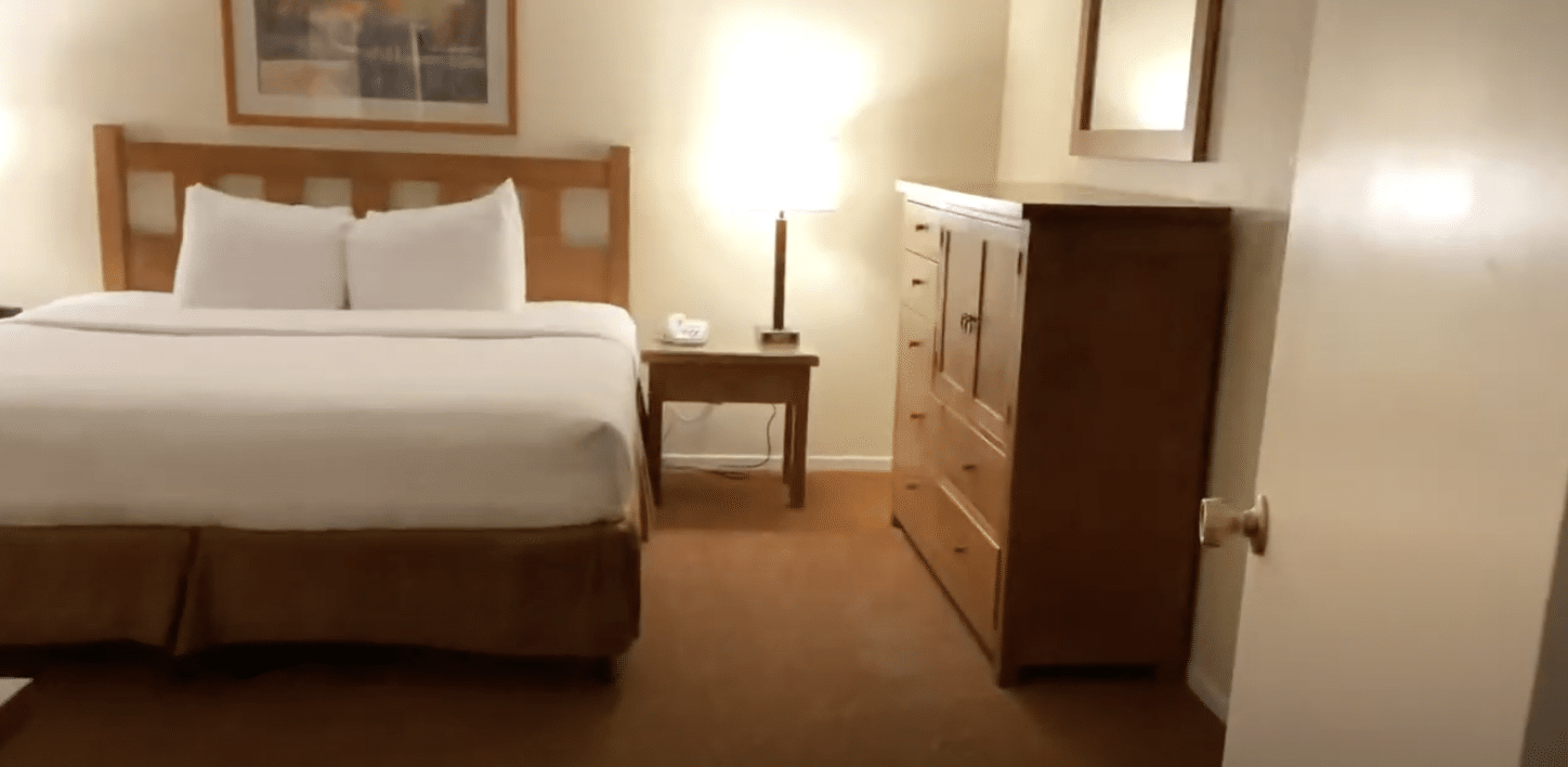bedroom, dresser, and nightstand in a 1 bedroom suite at Riviera Oaks Resort & Racquet Club