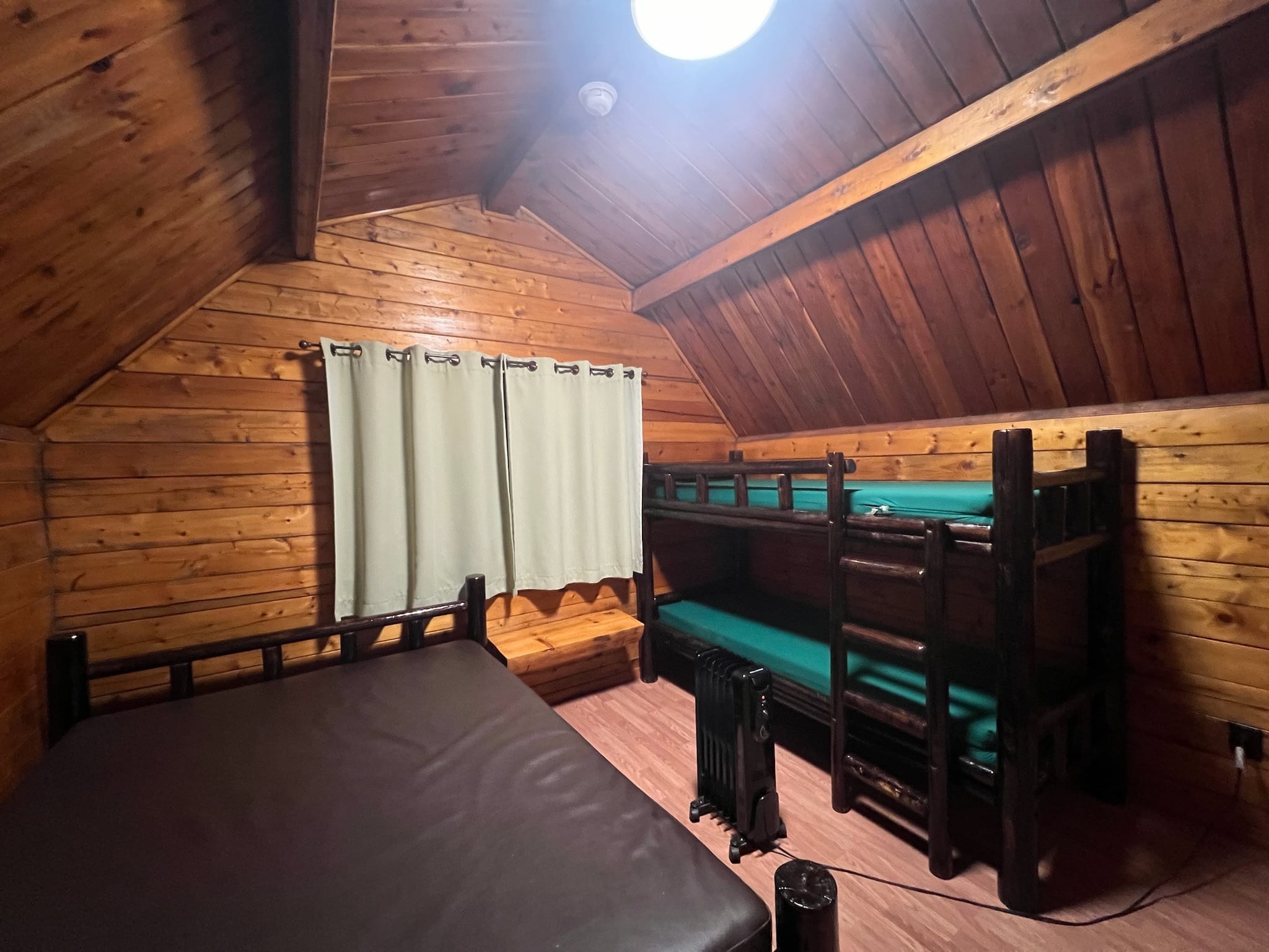 view inside the cabin of the full bed and bunk beds