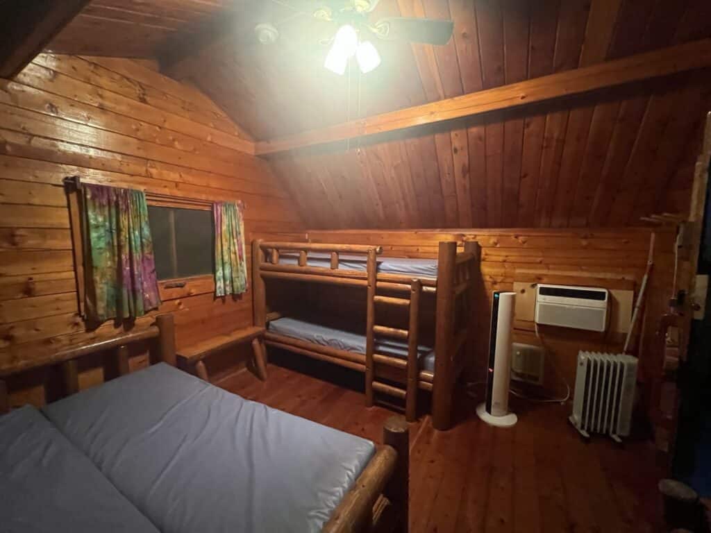 inside of the camping cabin at Joplin KOA Journey - beds, bunk bed, space heater