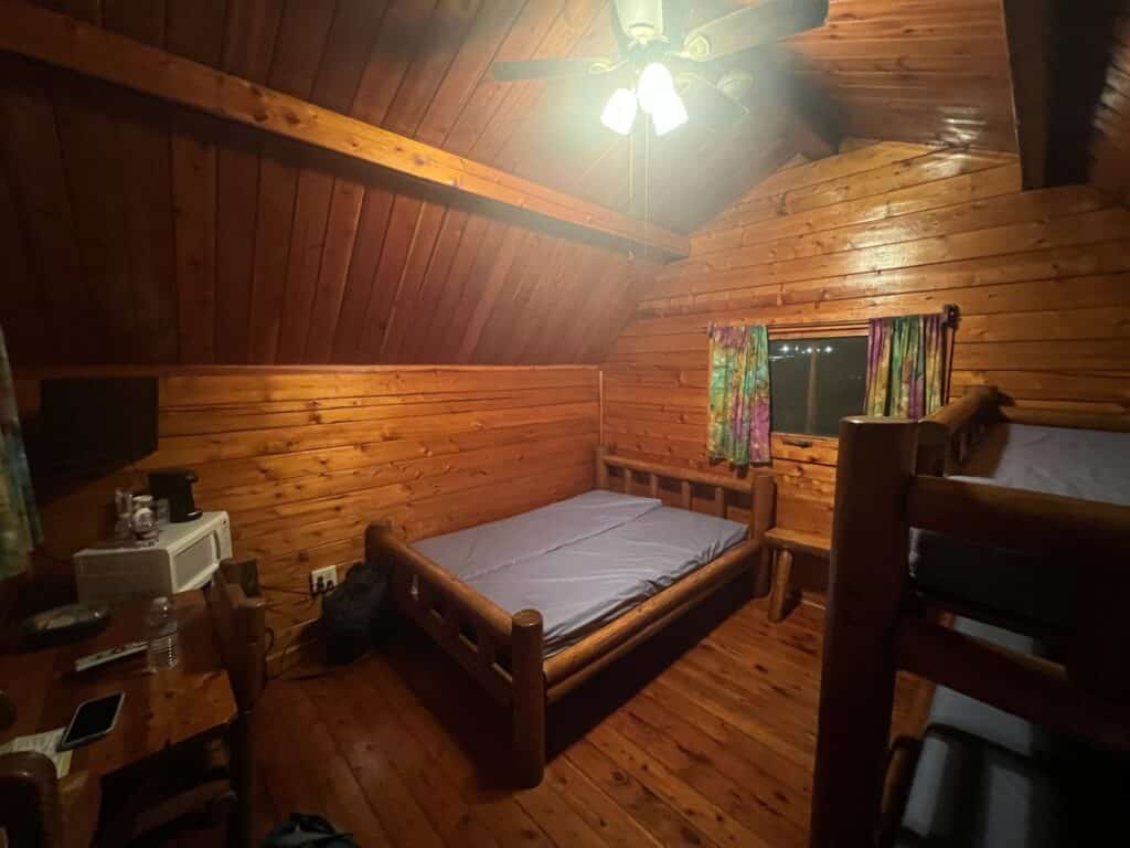 inside of the camping cabin at Joplin KOA - bunk bed, bed, tv, microwave, mini fridge, coffee maker, table