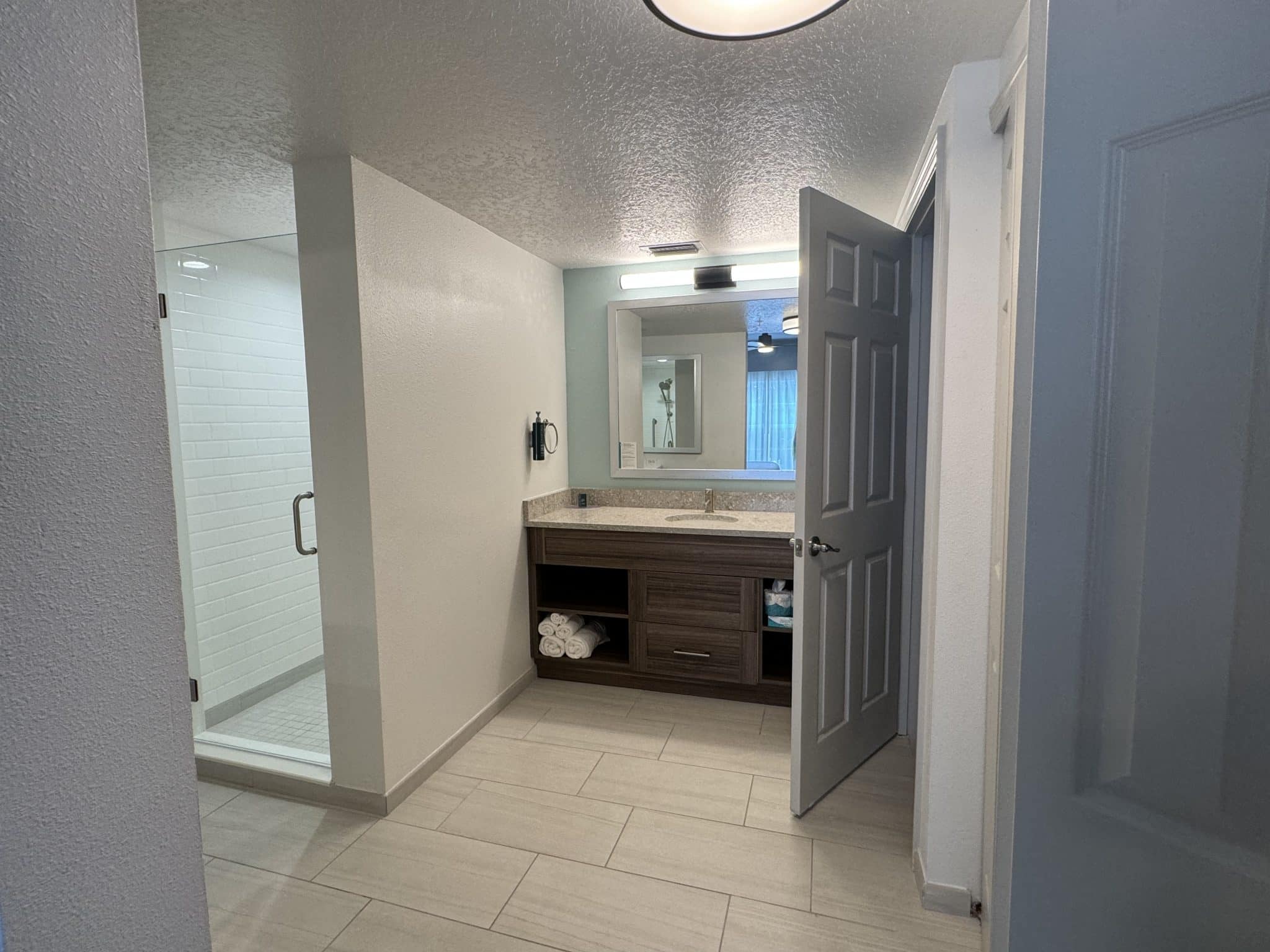 primary bathroom with large jacuzzi tub, glass door shower, vanity