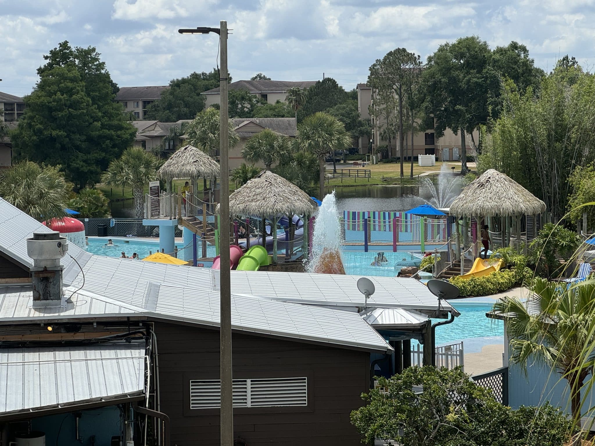view of the pool from the room with tiki huts, pools, and water fountains