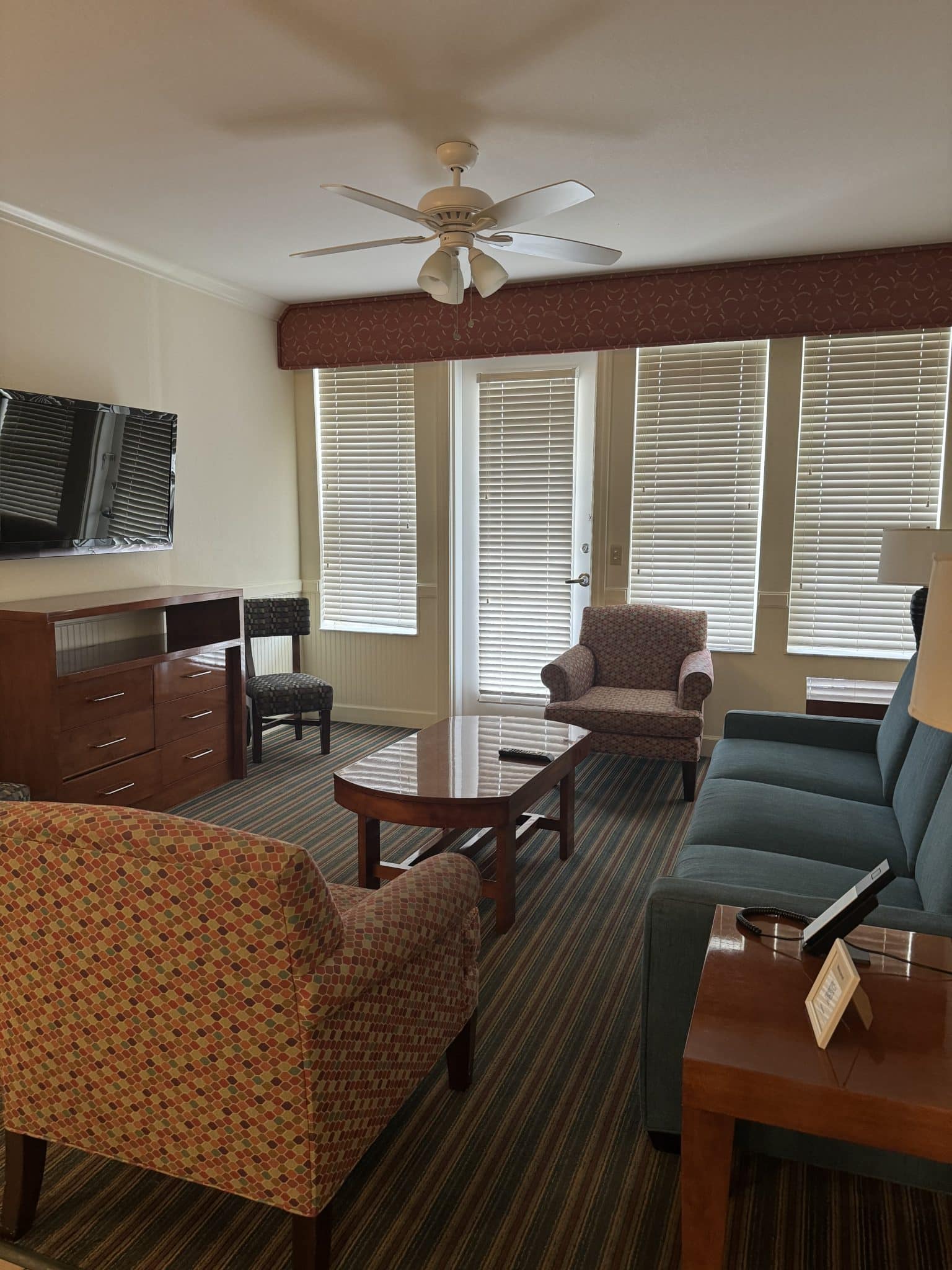 living room with a couch, chair, coffee tale, tv, fan, and patio