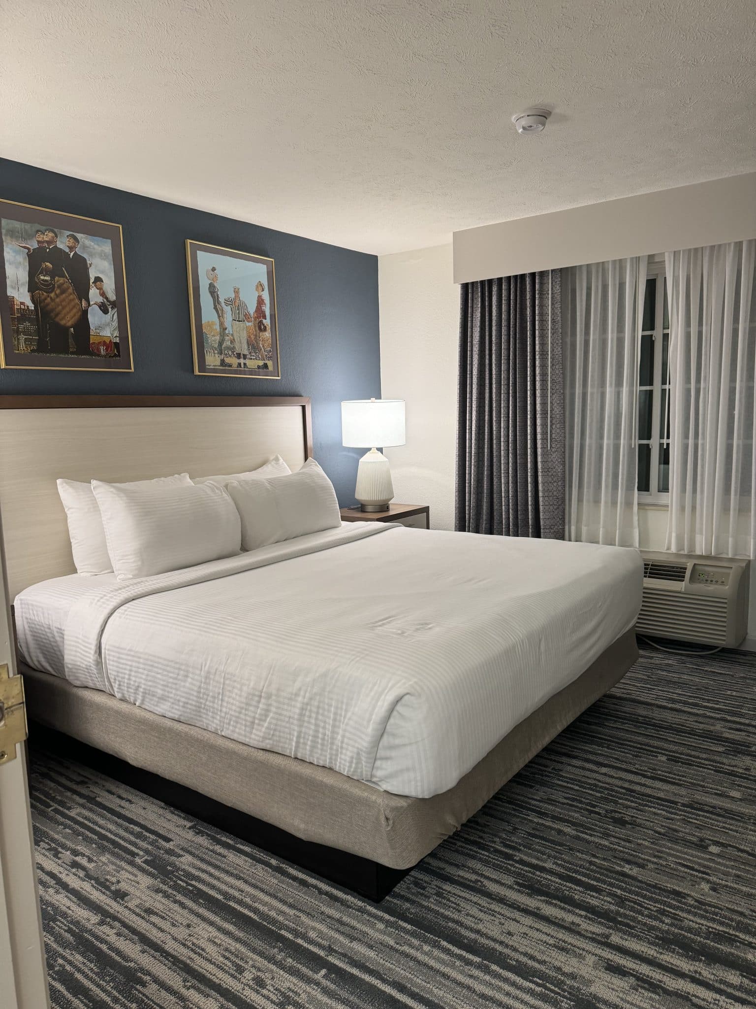 king bed in the one bedroom suite with sports related artwork