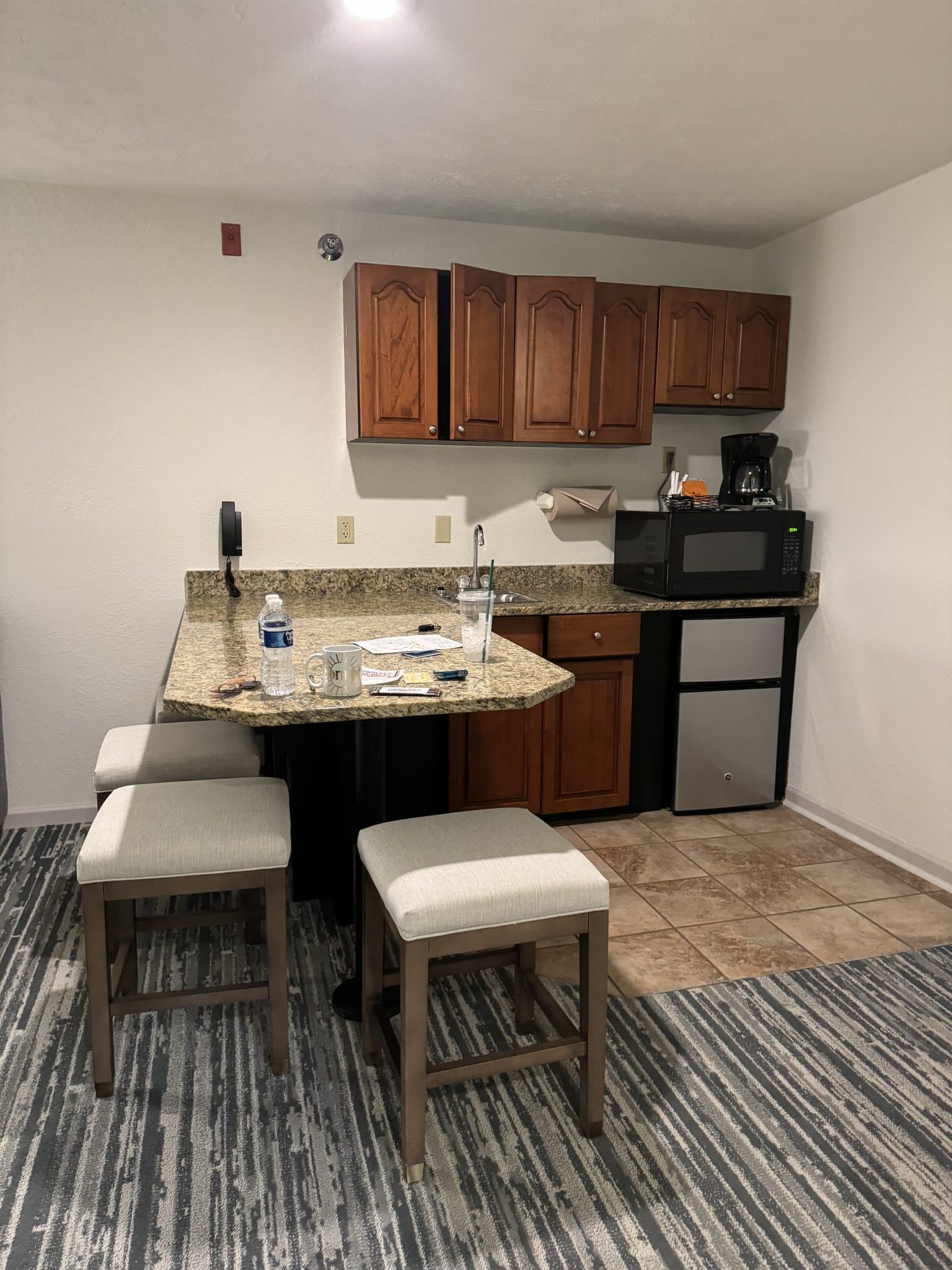 kitchenette with mini fridge, microwave, breakfast counter, and high top stools