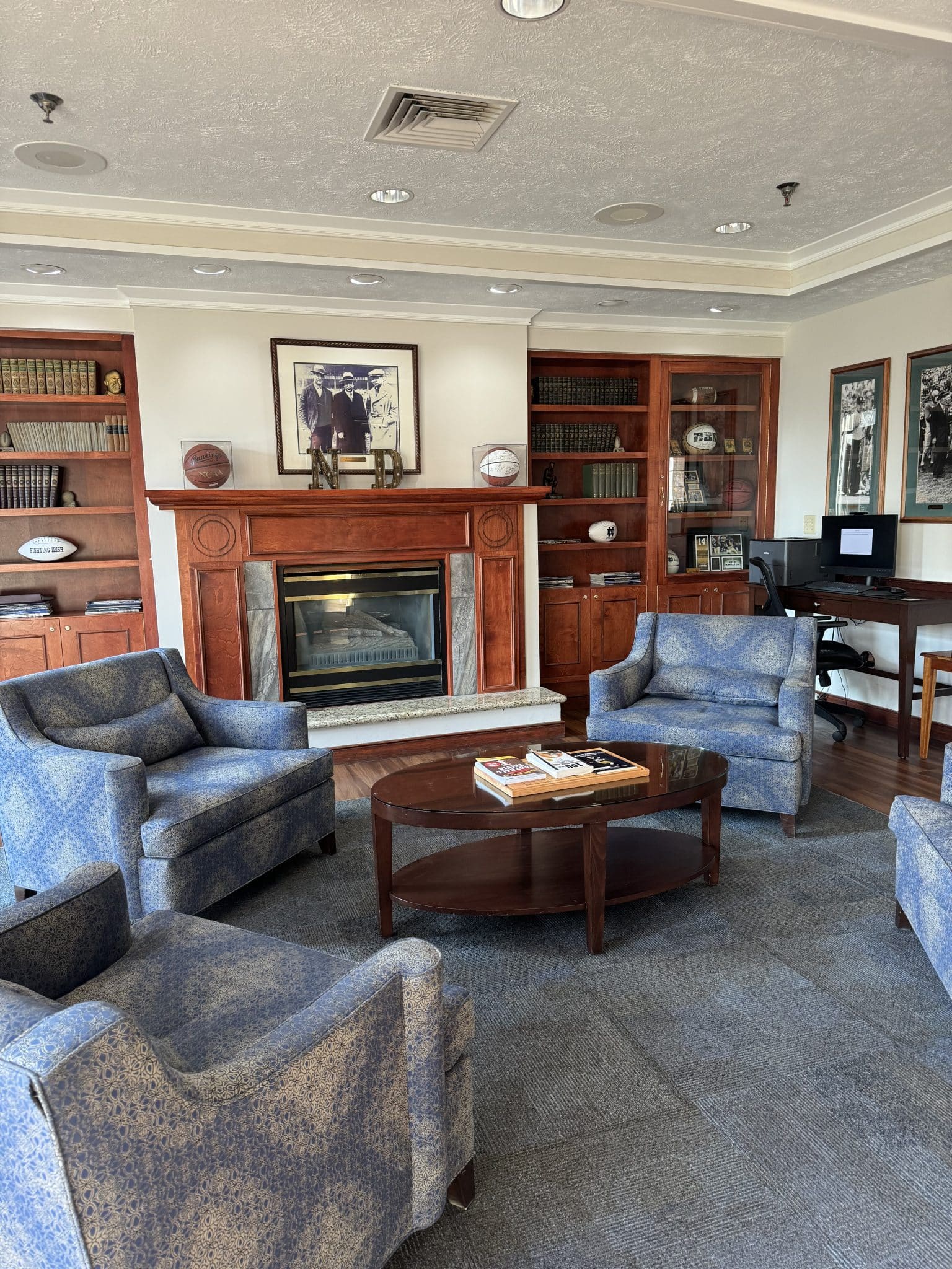 collegiate looking library/sitting room with a fire place and chairs