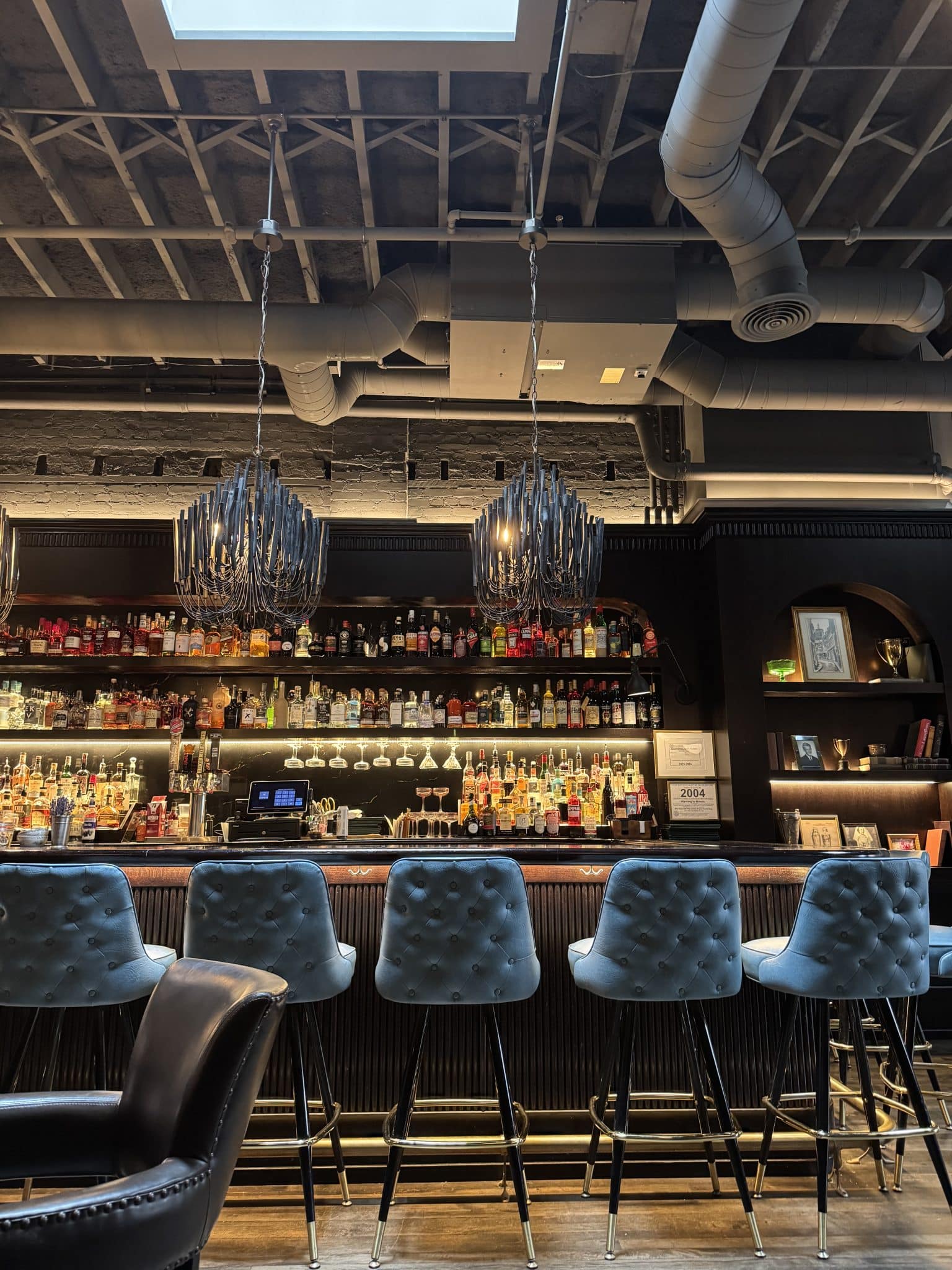 Scholar restaurant in Grand Rapids - bar with blue high top chairs and chandeliers