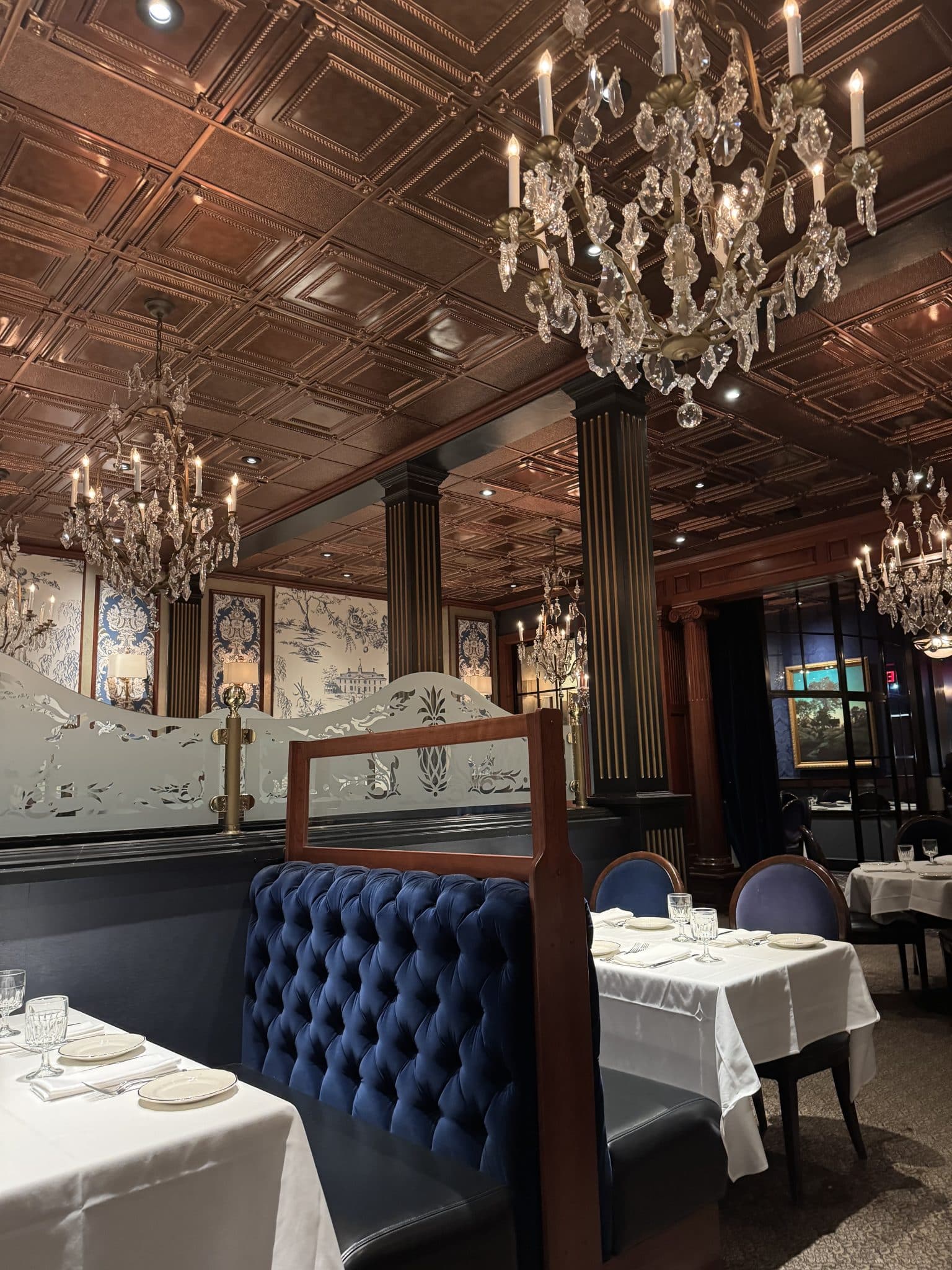 The Alcove restaurant in Mount Vernon, Ohio - chandeliers, tables and booths with white table cloths, and blue velvet on the booth seats