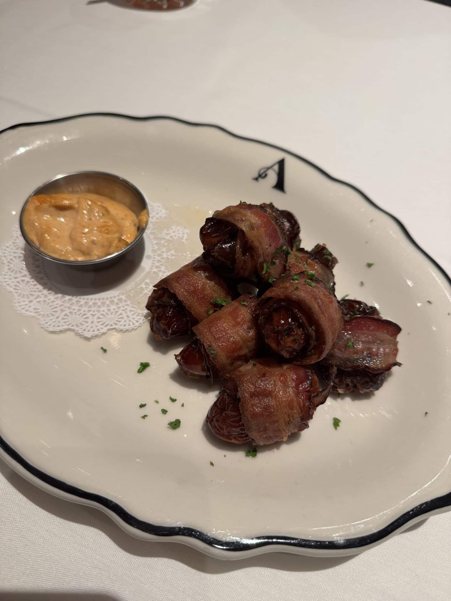 chorizo stuffed medjool dates wrapped in bacon with a dipping sauce from The Alcove restaurant in Mount Vernon, Ohio