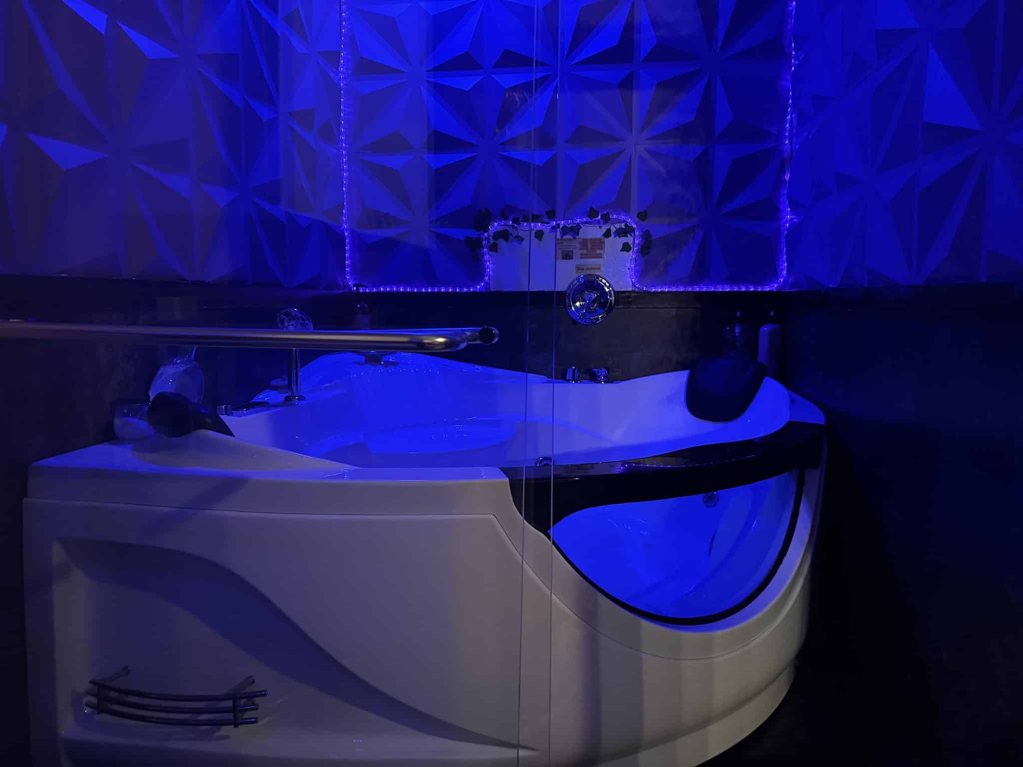 jetted bath tub with glowing lights, bath salts, and bubble bath mix